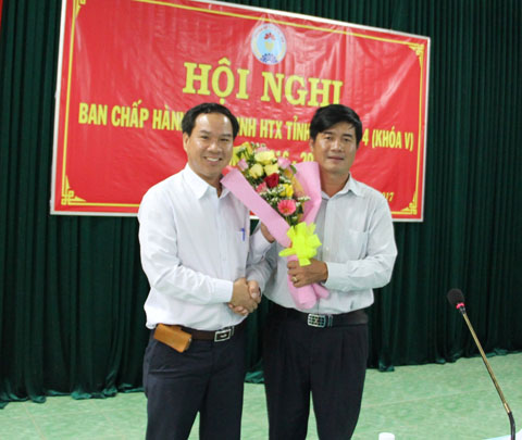 Chủ tịch Liên minh HTX tỉnh Nguyễn Thiên Văn (bên phải) tặng hoa chúc mừng ông Nguyễn Đình tương nhận nhiệm vụ mới