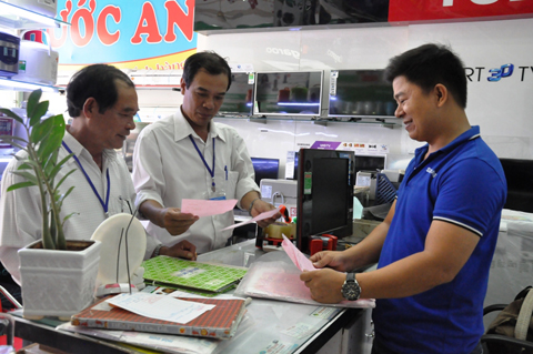 Cán bộ ngành Thuế tư vấn về hóa đơn cho một hộ kinh doanh trên địa bàn huyện Krông Pắc. 