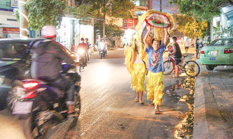  Một số  em nhỏ tổ chức  múa lân  trên đường Ama Khê (TP. Buôn Ma Thuột). 