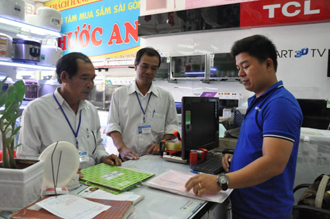Cán bộ Chi cục Thuế huyện Krông Pắc đôn đốc thực hiện nghĩa vụ thuế tại một cơ sở kinh doanh trên địa bàn