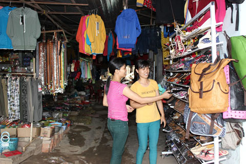 Tiểu thương Chợ 19-8 (huyện Cư Kuin) tư vấn, giới thiệu sản phẩm giày dép Việt với người tiêu dùng.