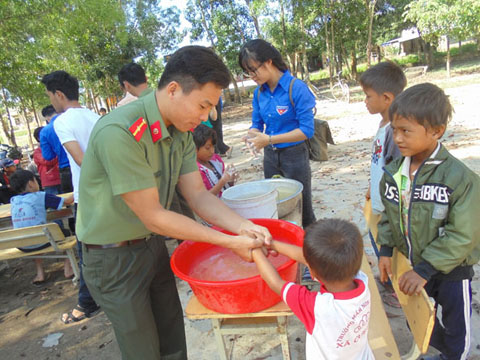 Đoàn viên, thanh niên Công an huyện Ea Kar hướng dẫn trẻ em xã Cư Elang rửa tay bằng xà phòng.