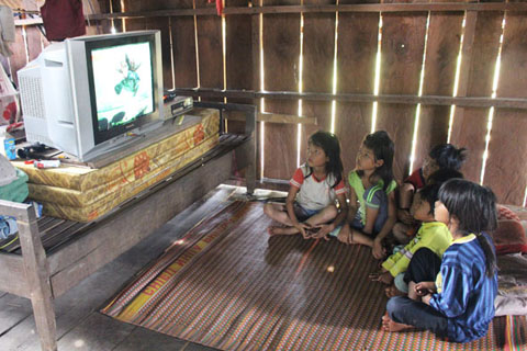 Trẻ em trong buôn Lách Ló quây quần bên nhau cùng xem TV.