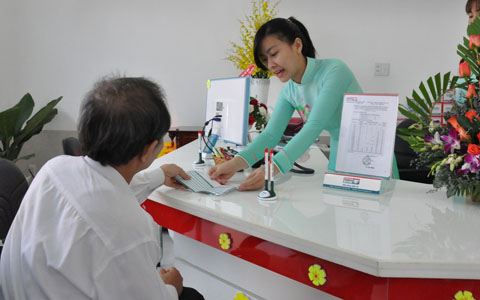 Nhân viên Ngân hàng TMCP Kiên Long Chi nhánh thị xã Buôn Hồ hướng dẫn khách hàng thực hiện giao dịch