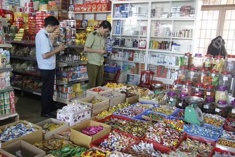 Kiểm tra việc bày bán bánh kẹo Tết tại cửa hộ kinh doanh ở thị xã Buôn Hồ. Ảnh: Đ. Lan
